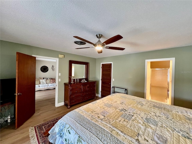 bedroom with ceiling fan, wood-type flooring, and a textured ceiling