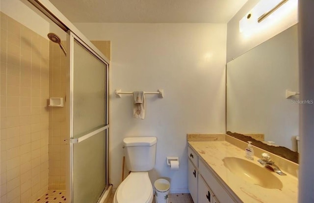 bathroom featuring tile patterned floors, vanity, an enclosed shower, and toilet