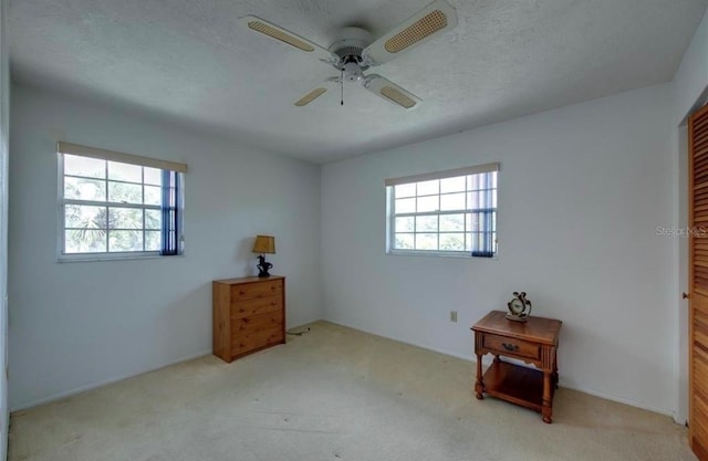 carpeted bedroom with a textured ceiling, a closet, multiple windows, and ceiling fan