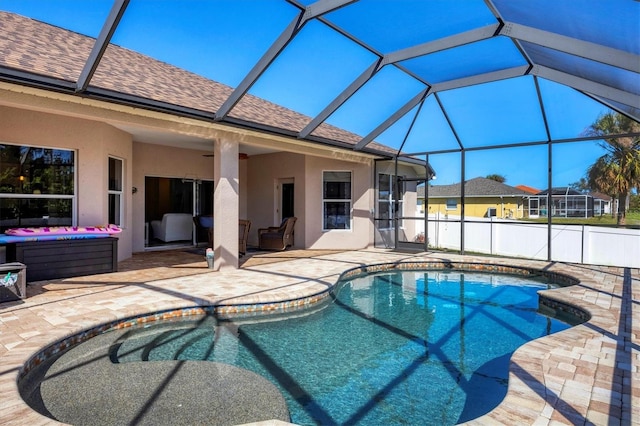 view of swimming pool featuring ceiling fan, a patio area, an outdoor hangout area, and glass enclosure