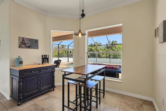 dining space featuring light tile patterned flooring and ornamental molding