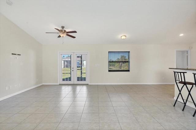 unfurnished room featuring ceiling fan, light tile patterned flooring, and french doors