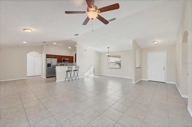 unfurnished living room with light tile patterned floors, ceiling fan with notable chandelier, and vaulted ceiling