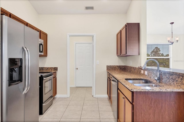 kitchen featuring stainless steel appliances, sink, a notable chandelier, hanging light fixtures, and light tile patterned flooring