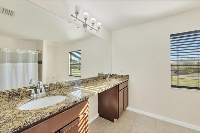 bathroom featuring tile patterned floors, vanity, and a healthy amount of sunlight