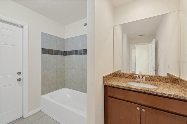 bathroom featuring tile patterned flooring, vanity, and tiled shower / bath combo