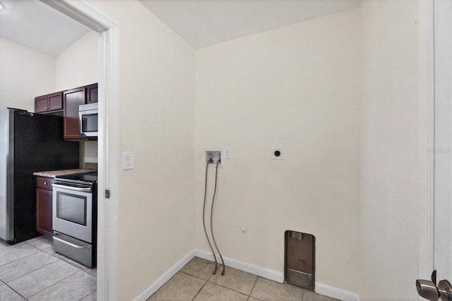 kitchen with light tile patterned floors and stainless steel appliances