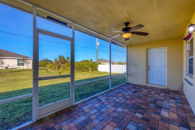 unfurnished sunroom with ceiling fan