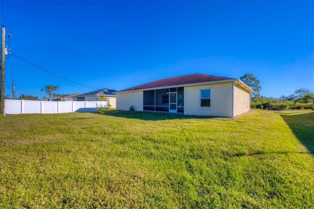 back of property featuring a sunroom and a yard