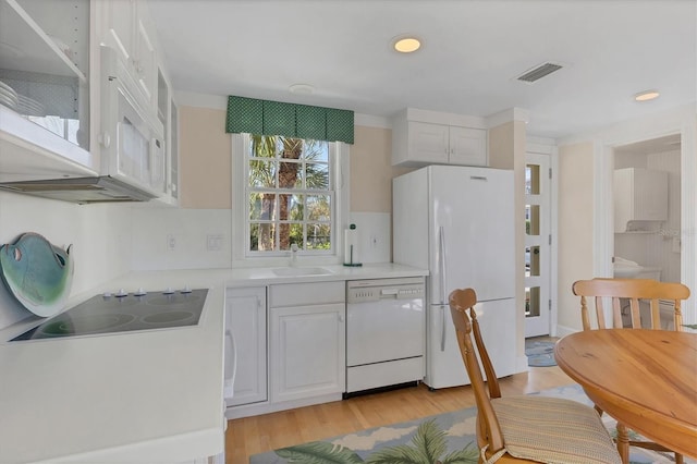 kitchen featuring white cabinets, white appliances, light hardwood / wood-style flooring, and sink