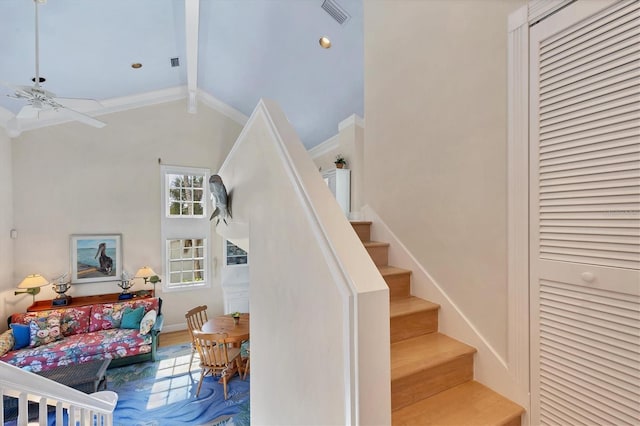 staircase featuring wood-type flooring, vaulted ceiling with beams, ceiling fan, and crown molding