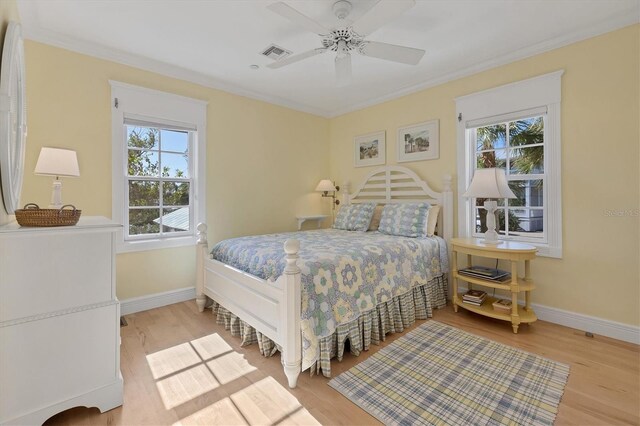 bedroom featuring ceiling fan, light wood-type flooring, and multiple windows