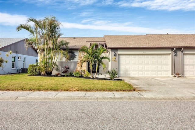 ranch-style house featuring cooling unit, a garage, and a front yard