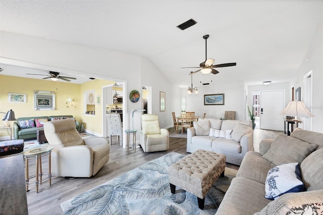 living room featuring light wood-type flooring, ceiling fan, and lofted ceiling