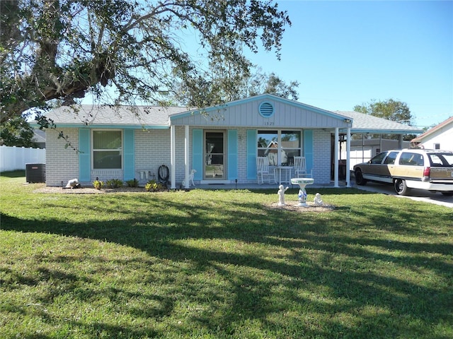 ranch-style house with cooling unit, a front lawn, and a carport