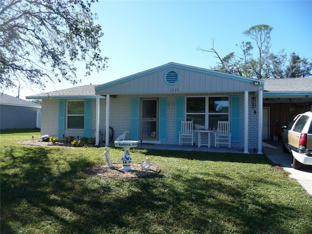 view of front of house with a front lawn, a porch, and a carport