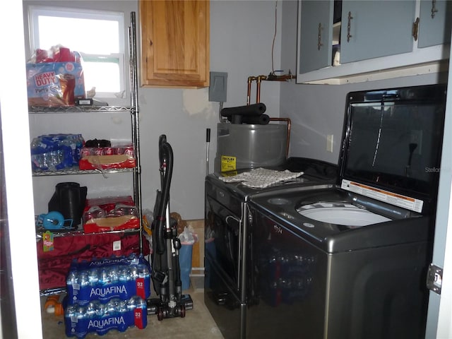 clothes washing area with cabinets and washing machine and clothes dryer