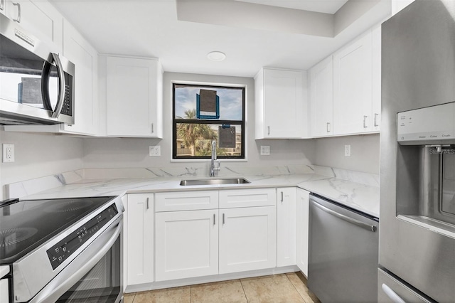 kitchen featuring light stone countertops, sink, white cabinetry, and stainless steel appliances