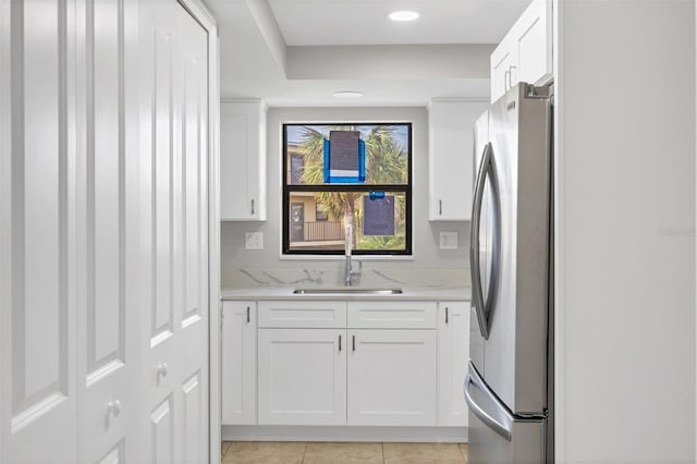 laundry area featuring cabinets, light tile patterned flooring, and sink