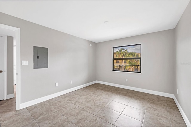 empty room featuring electric panel and light tile patterned floors