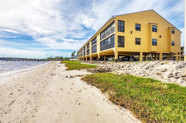 view of property with a water view and a beach view