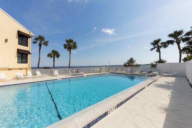 view of pool with a patio and a water view