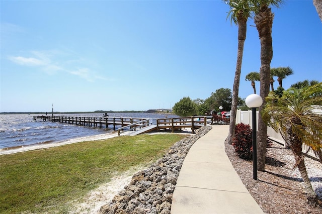 dock area featuring a water view and a beach view