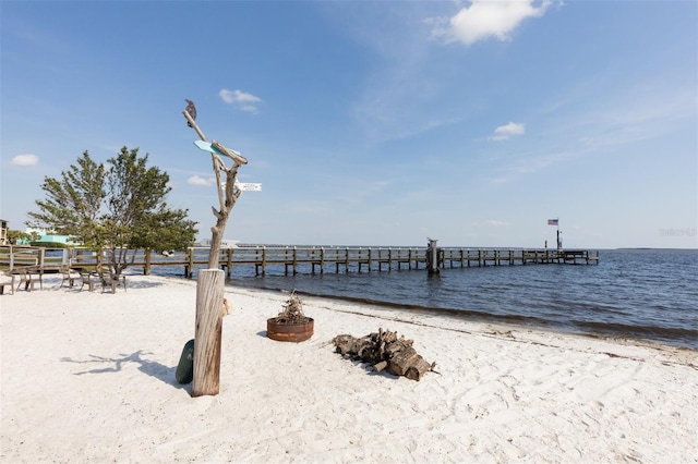 dock area featuring a beach view and a water view