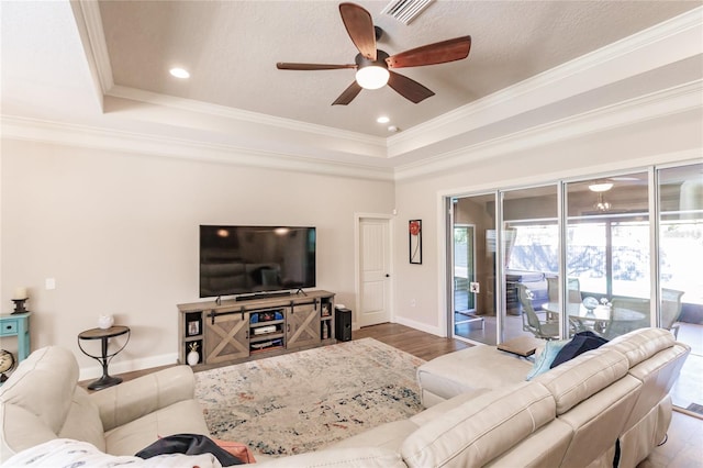 living room with crown molding, ceiling fan, and wood-type flooring