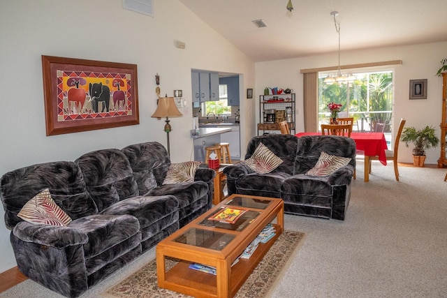 living room featuring a notable chandelier, carpet floors, and high vaulted ceiling