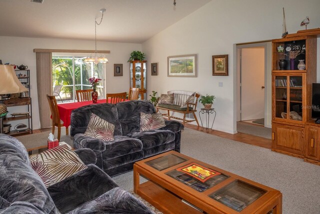 97 Mariner Ln, Rotonda West, FL 33947 - carpeted living area with a chandelier and vaulted ceiling