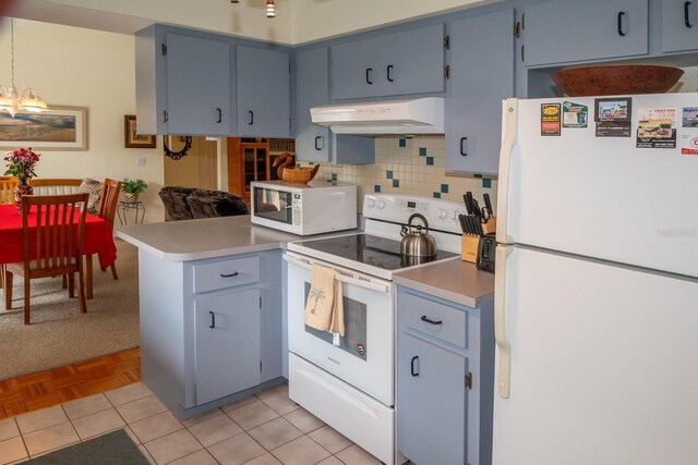 97 Mariner Ln, Rotonda West, FL 33947 - kitchen featuring white appliances, under cabinet range hood, a peninsula, tasteful backsplash, and light countertops