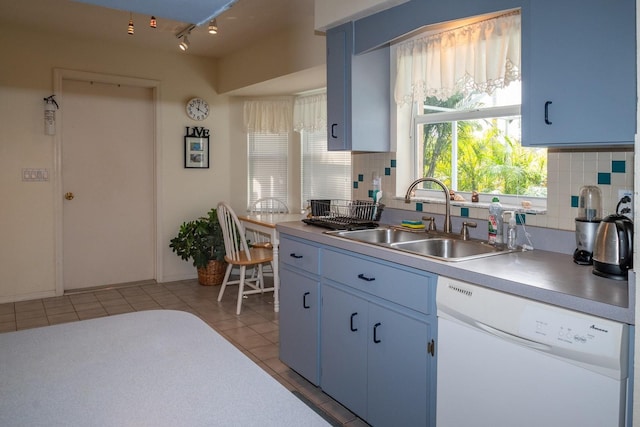 kitchen with dishwasher, sink, decorative backsplash, light tile patterned floors, and blue cabinetry