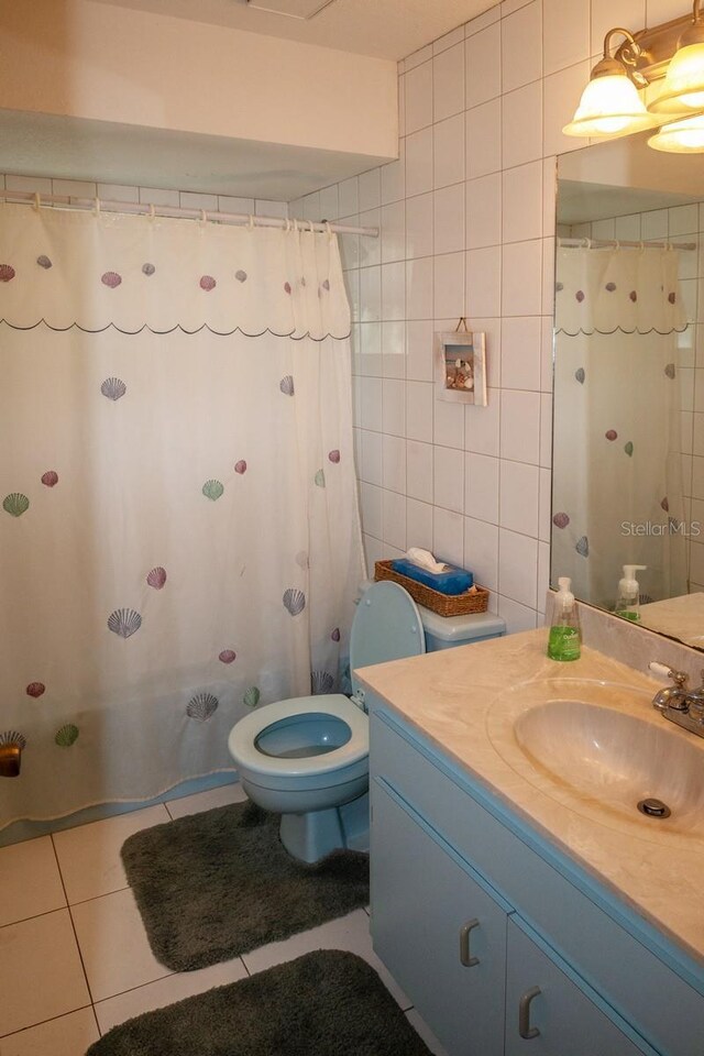 97 Mariner Ln, Rotonda West, FL 33947 - full bathroom featuring vanity, tile patterned flooring, toilet, tile walls, and a shower with shower curtain