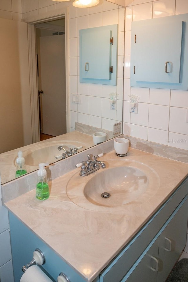 bathroom with decorative backsplash, vanity, and tile walls