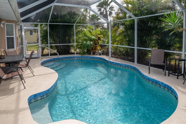 view of pool with a patio and glass enclosure