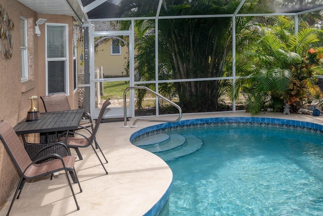 view of swimming pool featuring a patio and a lanai