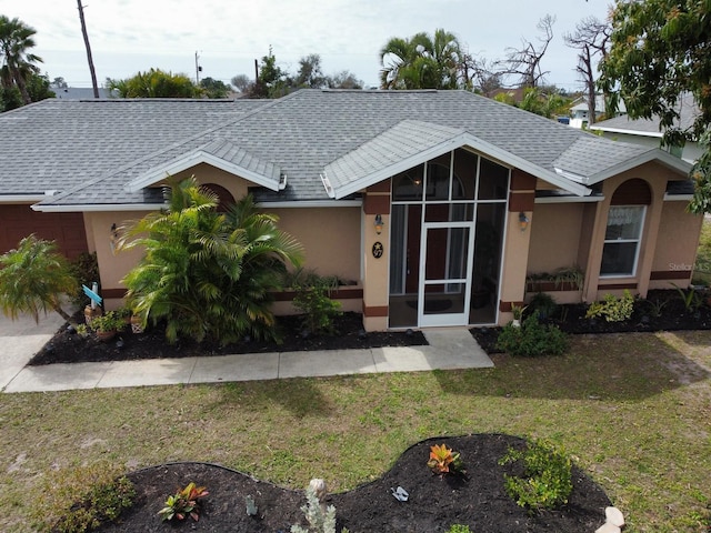 97 Mariner Ln, Rotonda West, FL 33947 - ranch-style home with a shingled roof, a front yard, and stucco siding