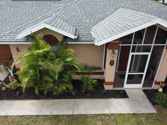97 Mariner Ln, Rotonda West, FL 33947 - entrance to property featuring stucco siding and a shingled roof