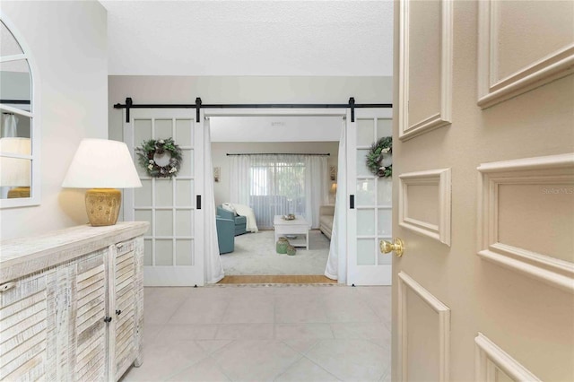 interior space with a barn door and a textured ceiling