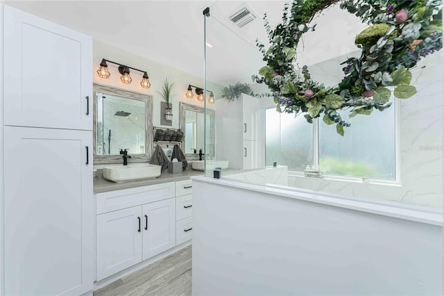 bathroom with vanity, wood-type flooring, and a shower with door