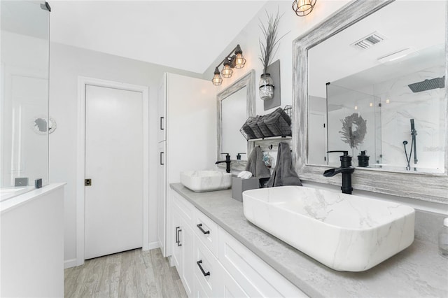 bathroom with a shower, hardwood / wood-style floors, and vanity