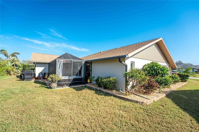 rear view of property with a lanai and a yard