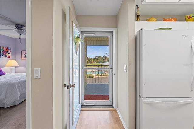 doorway to outside featuring light wood-type flooring and ceiling fan