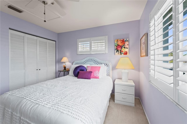 bedroom with ceiling fan, light colored carpet, and a closet