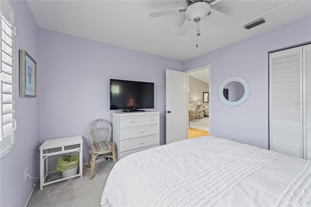 bedroom with ceiling fan, a closet, and light carpet