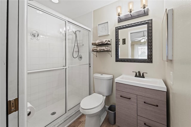 bathroom with toilet, vanity, an enclosed shower, and hardwood / wood-style flooring