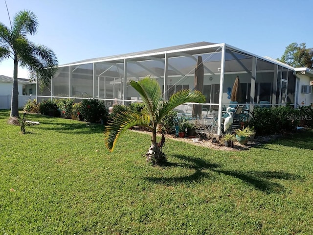 rear view of property featuring a lanai and a yard