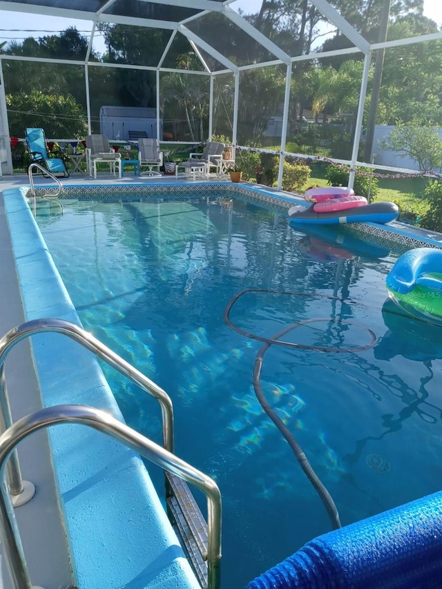 view of swimming pool with glass enclosure and a patio area