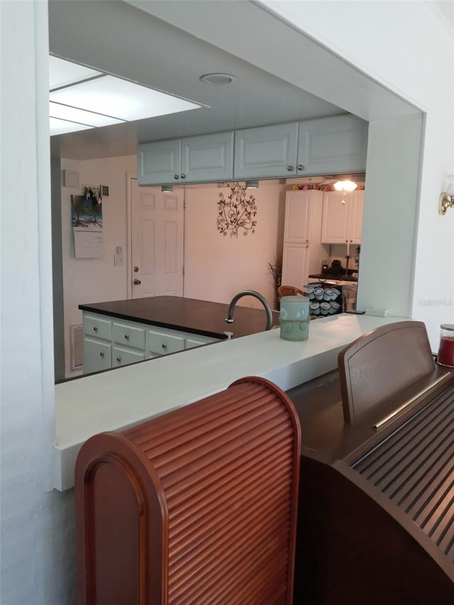 kitchen featuring sink, white cabinetry, and kitchen peninsula